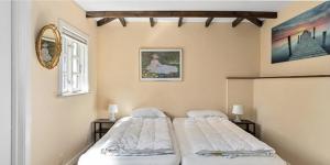 2 aparte bedden in een slaapkamer met een spiegel bij Swedish Timber House Overlooking Lake Arresø in Helsinge