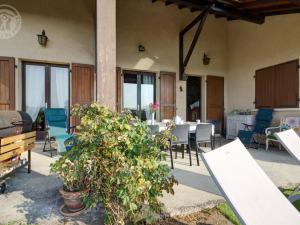 Un patio con una mesa y sillas y un árbol. en Gîte spacieux avec garage et terrasse dans un cadre verdoyant - FR-1-496-204, en Saint-Christo-en-Jarez