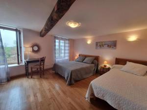 una camera da letto con due letti e una scrivania di Gîte spacieux avec cheminée et WiFi - Animaux admis - FR-1-496-87 a Saint-Paul-de-Vézelin