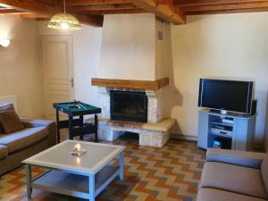 un soggiorno con camino e TV di Gîte spacieux avec cheminée et WiFi - Animaux admis - FR-1-496-87 a Saint-Paul-de-Vézelin