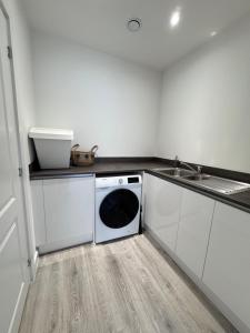 a kitchen with a washing machine and a sink at Eden Gateway full equipment brand new bright and modern En-suite Double bedroom - room 3 near city centre in Birmingham