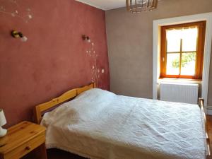 a bedroom with a bed and a window at Gîte spacieux à Renaison avec cheminée, jardin et équipements enfants - FR-1-496-257 in Renaison +9 photos