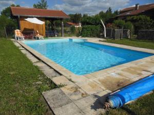 a large blue swimming pool in a yard at Gîte spacieux à Renaison avec cheminée, jardin et équipements enfants - FR-1-496-257 in Renaison