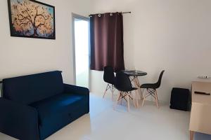 Una sala de estar con un sofá azul y una mesa. en Apartamento Excelente Liberdade SP, en São Paulo