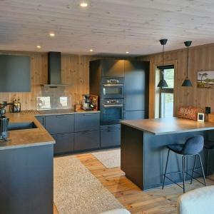 una cocina con armarios azules y una gran isla en Mountain Cabin With Sauna In Sunnmørsalpane, en Brunstad