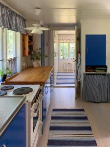 eine Küche mit blauen Schränken und einer Arbeitsplatte in der Unterkunft Family-Friendly Cottage Near The Sea In Ugglarp in Heberg