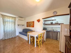 a living room with a table and a blue couch at Appartamenti Casa Rossi in Capoliveri