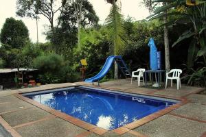 a small swimming pool with a slide and a playground at Ecohotel Villa Natalia in Boquía