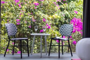 three chairs and a table with wine glasses on a balcony at MX Grand Suites in Mexico City +68 photos