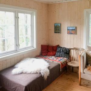a room with a bed and a window at Historic Forest Cabin By Lake Steinsvannet in Lundeby