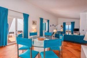 a living room with blue chairs and a table at Ocean Villa Algarve in Alvor