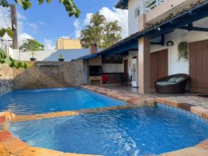 a swimming pool in the backyard of a house at Casa Tortuga 5 suítes 400 metros da praia in Guarujá