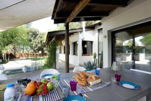 ein Tisch mit einem Teller Obst und Brot darauf in der Unterkunft Superb Contemporary Villa Near Montpellier in Castelnau-le-Lez