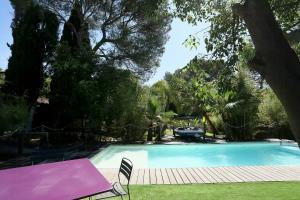 ein Swimmingpool in einem Hof mit einem rosa Tisch und Stühlen in der Unterkunft Superb Contemporary Villa Near Montpellier in Castelnau-le-Lez