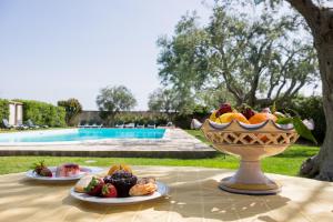 a table with a bowl of fruit and plates of food at Tenuta Arangio Agriturismo Vendicari in Casa Maccari