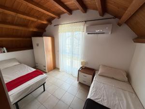 a bedroom with two beds and a window at South Italy summer house in Stazione di San Sostene