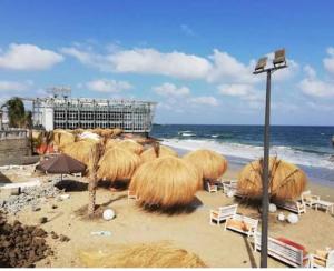 Un grupo de sombrillas y sillas de paja en una playa. en night holiday, en Alejandría 36 fotos más