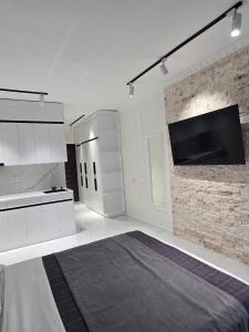 a white room with a bed and a wall mounted tv at Real Palace Apartment in Batumi +5 photos