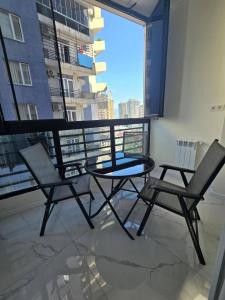 a table and two chairs on a balcony with a view at Real Palace Apartment in Batumi