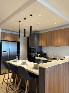 a kitchen with a table with chairs and a refrigerator at Luxury at Solaris Appartment in Accra