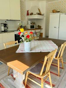 un tavolo da pranzo con un vaso di fiori sopra di Timmerhus Med Bastu Vid Ljungan a Sundsvall