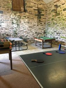 a room with two tables and a ping pong table at Large farmhouse in Snowdonia, North Wales in Talsarnau