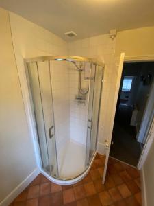 a shower with a glass door in a bathroom at Large farmhouse in Snowdonia, North Wales in Talsarnau +21 photos