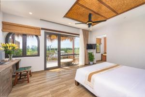 ホイアンにあるAlana Riverside Retreatのベッドとバルコニーのある寝室