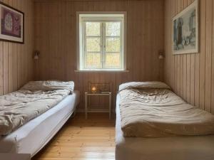 two beds in a room with a window at Holiday Home By Gudenå River With Natural Garden in Bjerringbro
