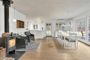 a kitchen and living room with a table and a fireplace at Holiday Home By Gudenå River With Natural Garden in Bjerringbro