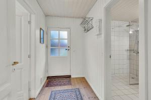 a bathroom with a shower and a white door at Holiday Home By Gudenå River With Natural Garden in Bjerringbro +23 photos