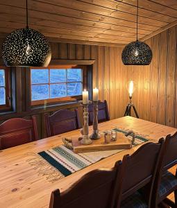 a dining room with a wooden table and two lights at Modernized Mountain Cabin Near Treungen in Drangedal