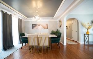 a dining room with a table and green chairs at Lush Hideaway with HotTub & Pool 6 mins kings Island in Mason