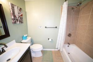 a bathroom with a toilet and a sink and a shower at Lush Hideaway with HotTub & Pool 6 mins kings Island in Mason