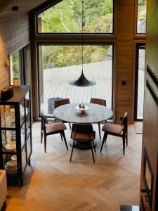 a dining room with a table and chairs and a large window at Stylish Cabin In Scenic Surroundings in Skare