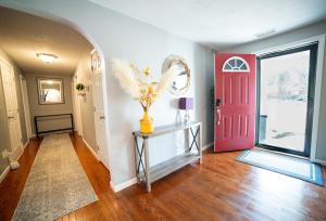 a hallway with a red door and a vase on a table at Lush Hideaway with HotTub & Pool 6 mins kings Island in Mason