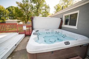 a jacuzzi tub sitting outside of a house at Lush Hideaway with HotTub & Pool 6 mins kings Island in Mason