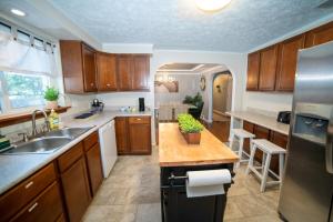 a large kitchen with wooden cabinets and a sink at Lush Hideaway with HotTub & Pool 6 mins kings Island in Mason