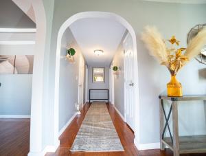 an archway in a hallway with white walls and wood floors at Lush Hideaway with HotTub & Pool 6 mins kings Island in Mason