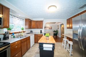a kitchen with wooden cabinets and stainless steel appliances at Lush Hideaway with HotTub & Pool 6 mins kings Island in Mason