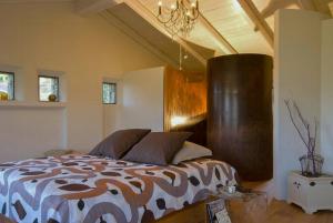 ドルチェアックアにあるStone Farmhouses Among Olives And Vinesのベッドとシャンデリアのある寝室