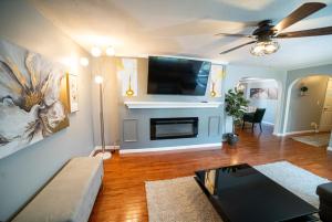 a living room with a ceiling fan and a tv at Lush Hideaway with HotTub & Pool 6 mins kings Island in Mason