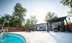 a backyard with a swimming pool and a wooden deck at Lush Hideaway with HotTub & Pool 6 mins kings Island in Mason