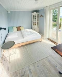 a bedroom with a bed and a table and a window at Romantic Country Cabin With Fjord Views On Åmøy in Stavanger