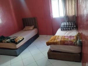 Dos camas en una habitación con paredes rojas. en Tranquil Rental Rooms in Agadir, en Agadir