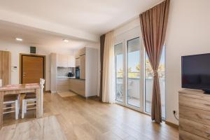 a living room with a table and a large window at Chez Vous in Ulcinj