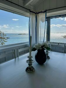 a table with two candles and a vase with flowers at Family Cabin By The Sea With Private Pier in Ula