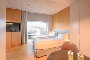 una camera d'albergo con un letto e una televisione di Placid Hotel Design & Lifestyle Zurich a Zurigo