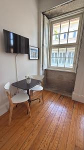 een eetkamer met een tafel en stoelen en een raam bij Great&Cosy São Bento in Porto