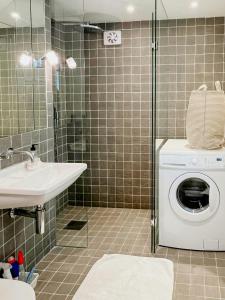 a bathroom with a washing machine and a sink at Serene Waterfront Oasis Your Resarö Sanctuary in Vaxholm +31 photos